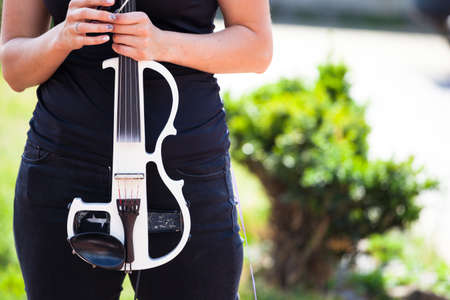 white electric violin in the hand of a young girlの写真素材