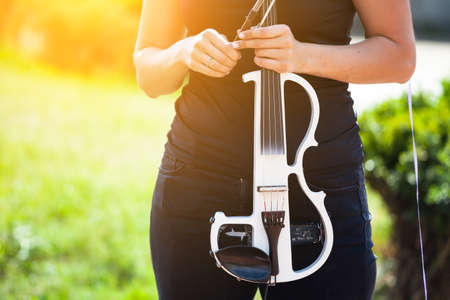white electric violin in the hand of a young girl, tonedの写真素材