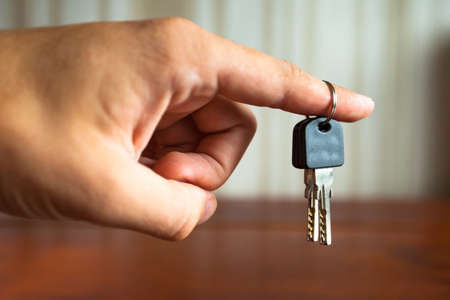 the keys to the apartment door in the man's hand