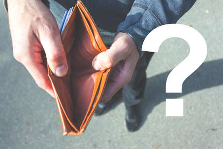A man holds in his hands and shows a wallet without money, question mark image, retro toned