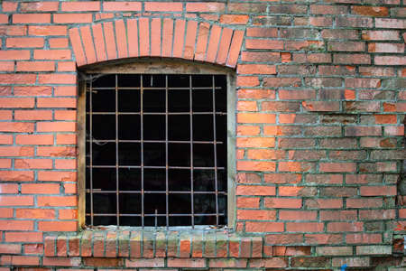 old red brick wall with bars on the window