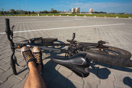 the guy sits next to the bike with his legs stretched outのeditorial素材