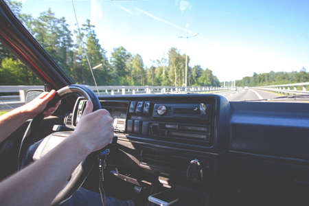 view of the hands on the steering wheel of the car, toned