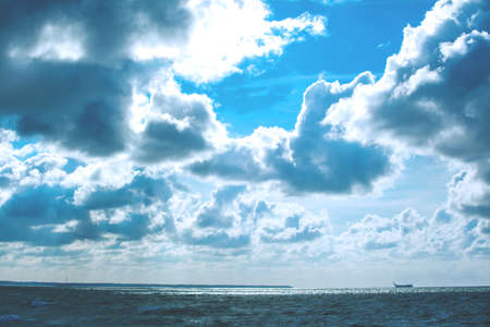 sea with waves under the sunny cloudy sky, toned