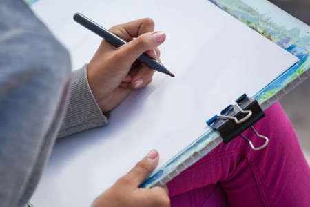 girl painter draws outdoors, close up