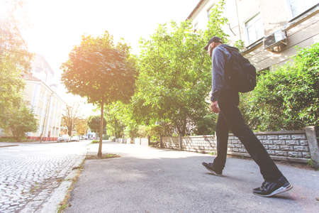 tourist man walking along the old city street on a sunny afternoon, tonedの写真素材