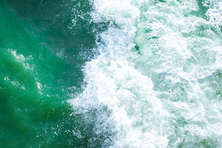 surface of turquoise ocean water with white foam, background, textureの写真素材