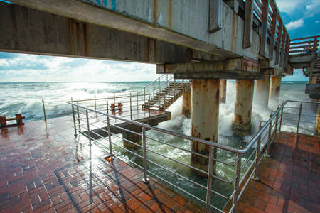 view of the sea and waves under the pierの写真素材