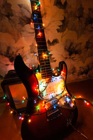 Electric guitar in bright colors of festive lights of the garland