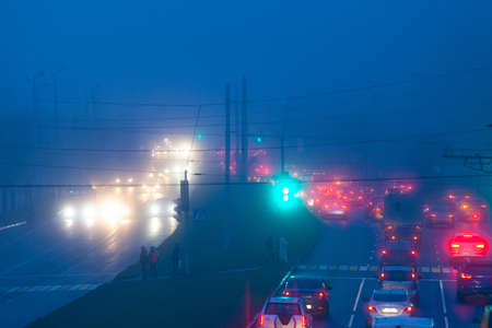 car lights at night on a wide foggy roadの写真素材