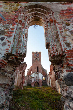 The ruins of the bell tower of the old medieval red brick churchの写真素材