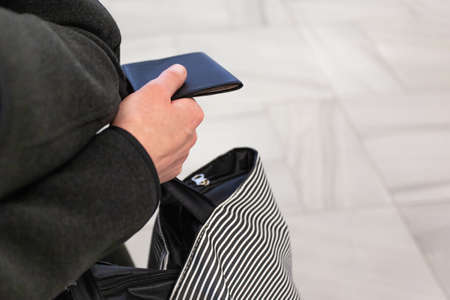 passport and bag in the hand of a girl, close up