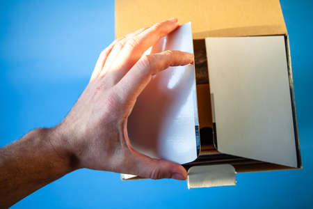 man opens a big box with a gadget