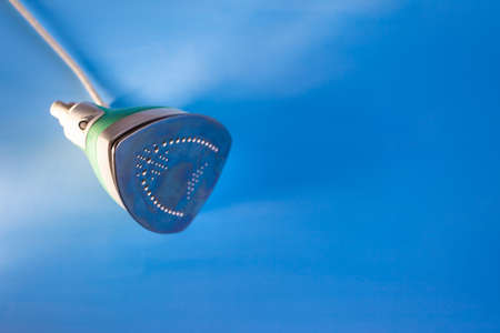 home laundry iron on a blue surface, copyspaceの写真素材