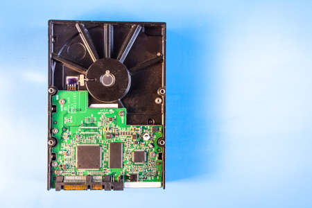 top view of a hard disk and chips on a blue surface, copyspace