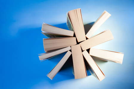 Stack of old books close up on blue background, copyspace
