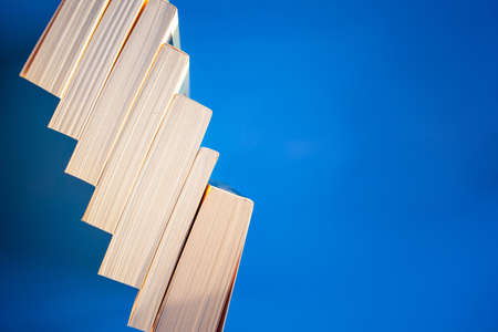 Stack of old books close up on blue background, copyspaceの写真素材