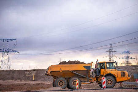 big yellow truck with land in the back of the quarryの写真素材