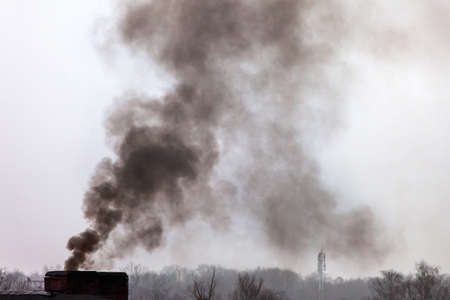 black smoke from the chimney against the sky