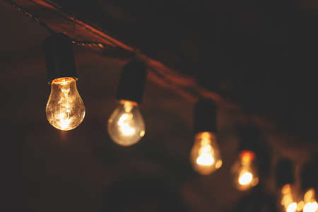 a garland of incandescent bulbs with warm light, retro toned