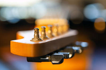 close up of the peg on the fingerboard of an blurred electric guitarの写真素材