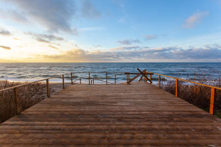 view of the colorful sunset over the sea from a wide wooden verandaの写真素材