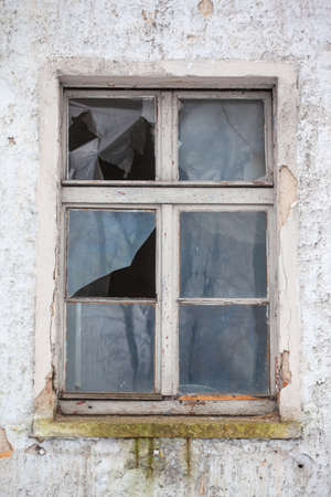 broken glass in the window of an abandoned houseの写真素材