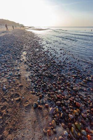 colorful little pebbles on the beach at sunset