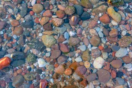 seabed from small pebbles through clear water, backgroundの写真素材