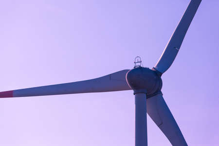 silhouette of wind turbine blades against a purple skyの写真素材