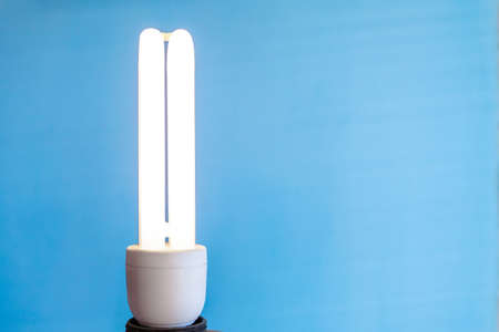 bright energy-saving light bulb on a blue background, copy space