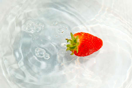 bright red ripe strawberries under waterの写真素材