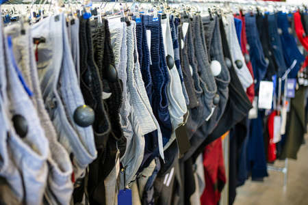 assortment of pants on a hanger in a storeの写真素材