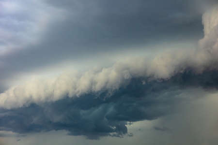 big bright thundercloud in a gray stormy skyの写真素材