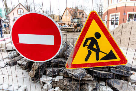 road signs no entry and repair work on the background of a pile of stones on the streetの写真素材