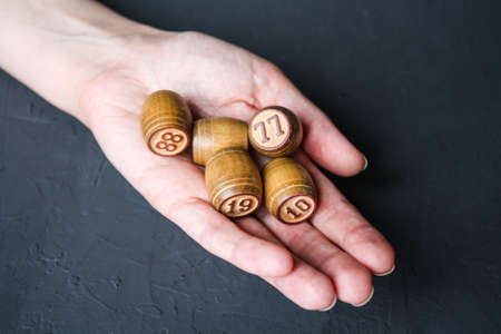 Lotto game. A woman holds a Lotto barrel against a black background.の写真素材