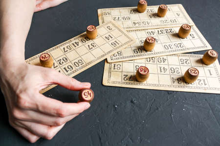 A Lotto game, a woman puts barrels on cards with numbers.の写真素材
