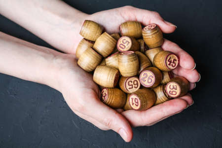 Lotto game. A woman holds a Lotto barrel against a black background.の写真素材
