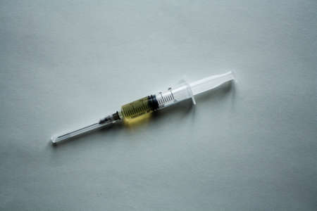 A syringe filled with medicine located on a white background.の写真素材