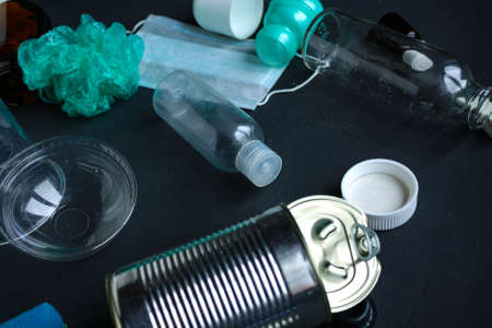 Recycling garbage is scattered on a dark surface.の写真素材