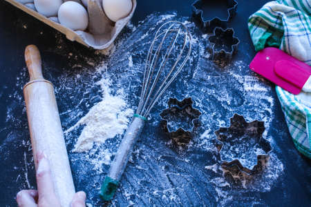 Baking utensils and ingredients are spread out on the dark surface.の写真素材