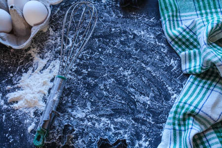 Baking utensils and ingredients are spread out on the dark surface.の写真素材
