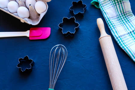 Baking utensils and ingredients are spread out on the dark surface.の写真素材