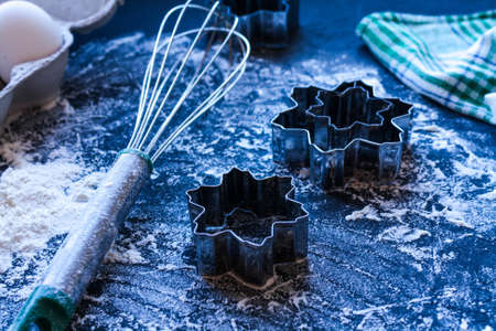 Baking utensils and ingredients are spread out on the dark surface.の写真素材