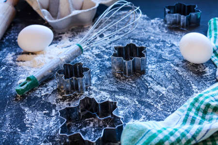 Baking utensils and ingredients are spread out on the dark surface.の写真素材