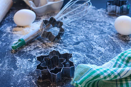 Baking utensils and ingredients are spread out on the dark surface.の写真素材