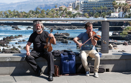 Two people playing the violin in San Telmo promenade located in the Spanish town of Puerto de la Cruzのeditorial素材