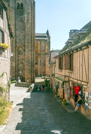 CONQUES, AVEYRON, FRANCE - SEPTEMBER 2014. Anonymous people walking through the streets of the...