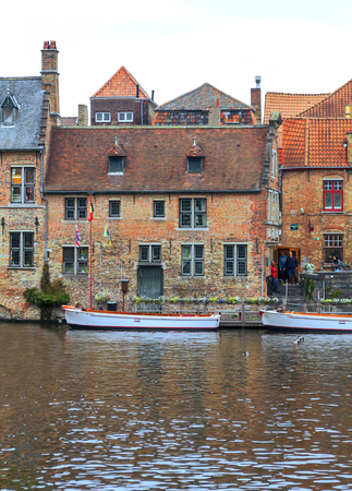 BRUGES, FLANDERS, BELGIUM-SEPTEMBER 2014. Streets of Bruges in Belgium with its medieval style facades on a cloudy day. You see people walking through them.のeditorial素材