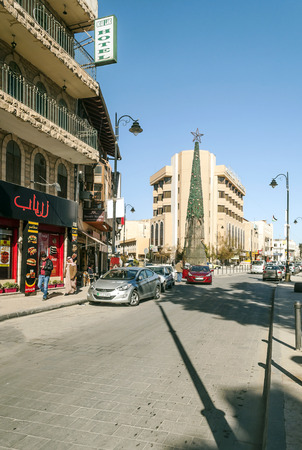 MADABA, JORDAN-FEBRUARY 2015. Street with cars circulating and people walking on a sunny day in Madaba, Jordan.のeditorial素材